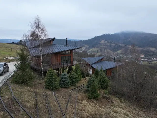 Реальне фото — два котеджі Тишагора на схилі з видом на Slavske і Карпати